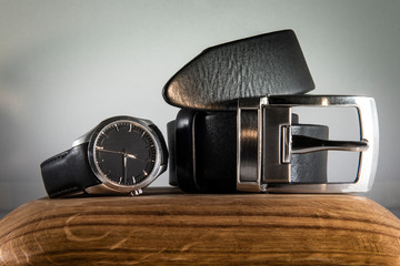 men's accessories. clock and a belt on a wooden support. Concept for execution of the section of...