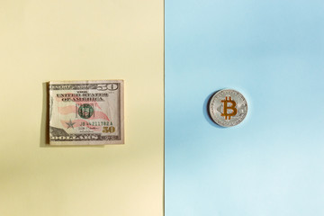 Bitcoins and dollars on a pastel background, the concept of choice between cryptocurrency and paper money