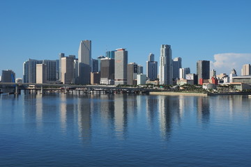 Fototapeta na wymiar Miami, Florida 09-15-2018 The City of Miami skyline and its reflection on a very calm Biscayne Bay in morning light.