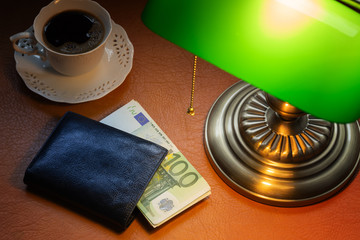Euro, European money, on a stylish desk lit with a banking lamp