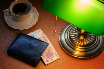 Argentine money, pesos, on a stylish desk lit with a banking lamp