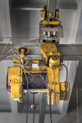 Hoist with winch. A tool for moving goods in a production room. Mechanization of labor.