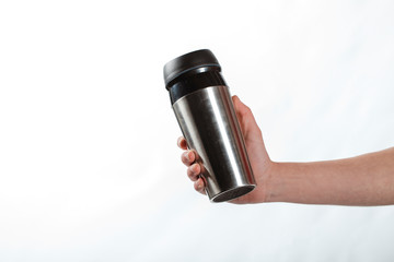 hand holding a bottle. thermos