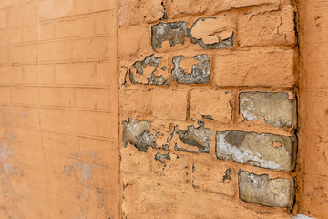 An old brick wall with broken paint. Selective focus close-up photo.
