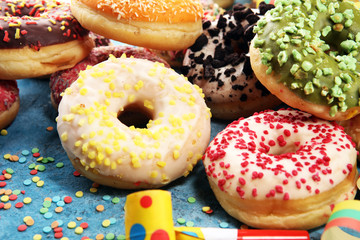 assorted donuts with chocolate frosted, pink glazed and sprinkles donuts