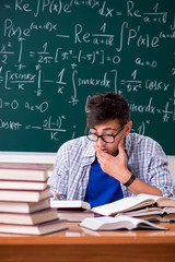 Young male student studying math at school