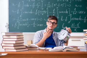 Young male student studying math at school