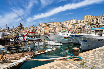Fishing boats moored at Sciacca harbour with the colorful old town buildings on the background, Sicily, Italy - obrazy, fototapety, plakaty