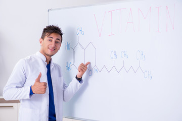 Young chemist standing in front of the whiteboard 