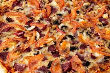 Bavarian pizza with sausages and mushrooms, juicy tomatoes and Parmesan