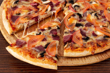 Bavarian pizza with sausages and mushrooms, juicy tomatoes and Parmesan