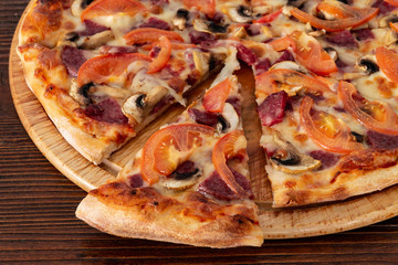Bavarian pizza with sausages and mushrooms, juicy tomatoes and Parmesan