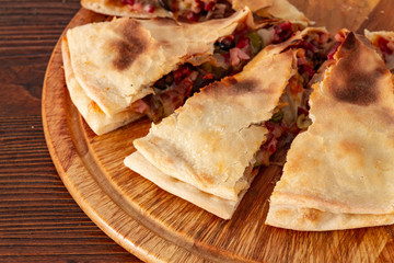 Pizza calzone on the textured table, for the restaurant menu, cafe, advertising.