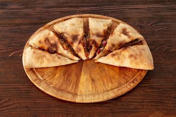 Pizza calzone on the textured table, for the restaurant menu, cafe, advertising.