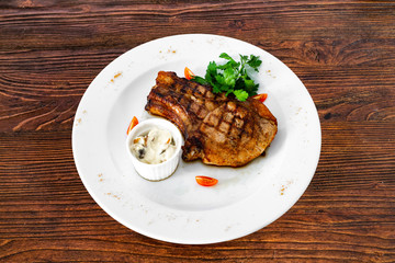 pork chop with vegetables in a white plate