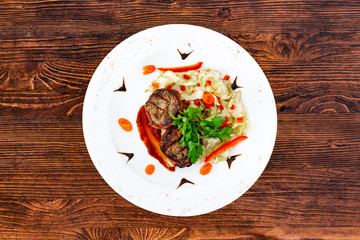Juicy beefsteak minion from medium rare beef with a sauce on a white plate