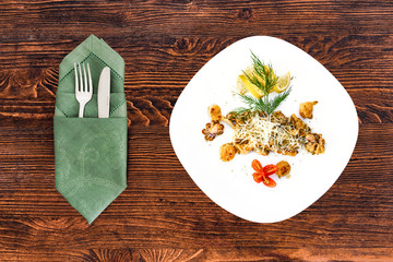 Seafood on a plate with appliances on a wooden table, a dish for the menu and advertising.