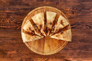 Pizza calzone on the textured table, for the restaurant menu, cafe, advertising.