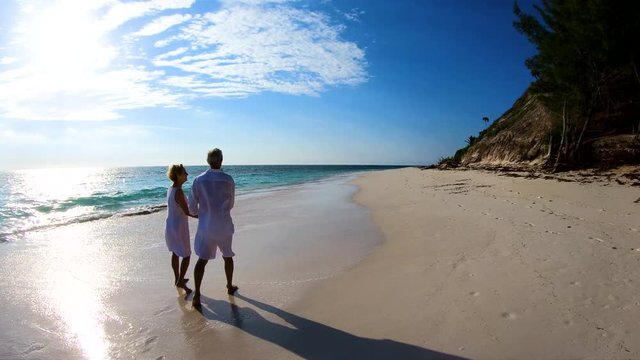 Loving senior couple walking on beach vacation Bahamas