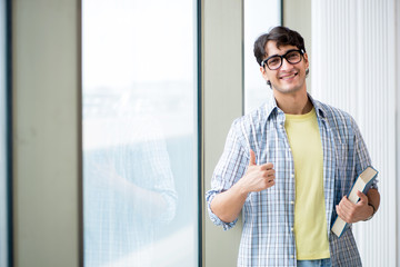 Young handsome student standing at the window 