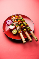 Chicken Hariyali kakab or Malai malai kebab served with skewers and yogurt dip in a plate. selective focus