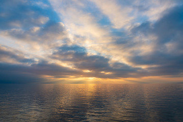 Naklejka na ściany i meble Horizontal skyline of twilight blue and gold colorful sunset or sunrise sky on lake. 