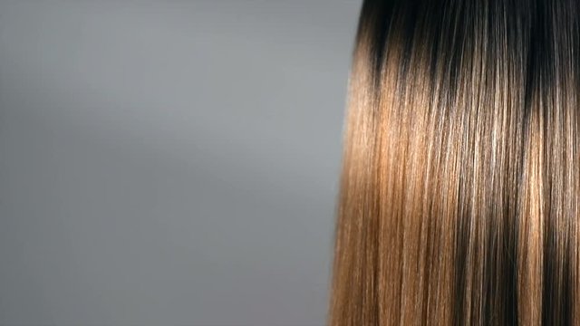 Hair. Beautiful healthy long smooth flowing brown hair closeup texture. Dyed straight hair background. Slow motion. 3840X2160 4K UHD video footage