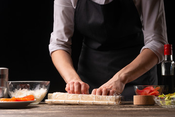 Nori and white rice. Women's hands are touching rice. The chef starts cooking sushi. A simple recipe for Hosomak rolls
