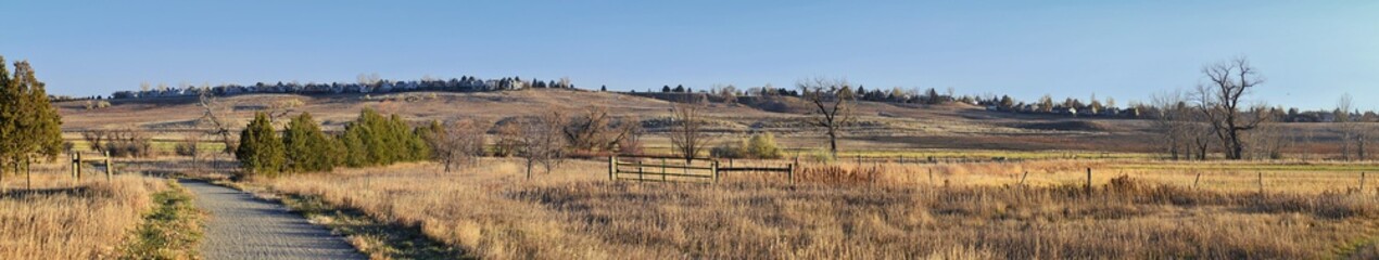 Views from the Cradleboard Trail walking path on the Carolyn Holmberg Preserve in Broomfield Colorado surrounded by Cattails, wildlife, plains and Rocky mountain landscape during fall close to winter.