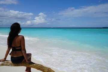 Obraz premium Asian woman sitting, overlooking the ocean in the Maldives