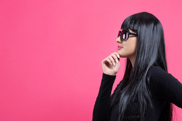 Fashionable woman in sunglasses on a pink background