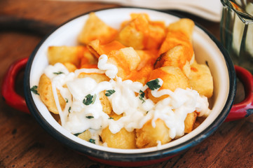 Famous Spanish Tapas Patatas Bravas served with spicy tomatoe sauce and mayonnaise