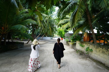 Fototapeta na wymiar Two women walking in Kamadhoo, Maldives