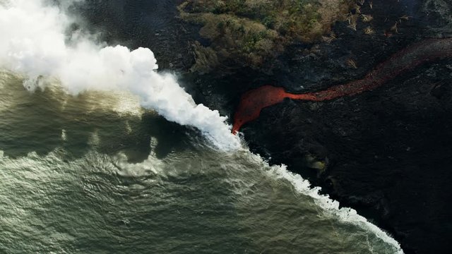 Aerial view of molten volcanic lava entering ocean