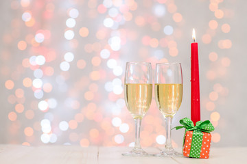 Pair glass of champagne withcandle and  gift box on festive background with copy space for your text. Valentine day concept