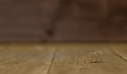 two golden wedding rings on wooden background. Empty space for text