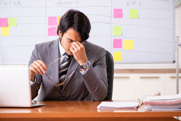 Young handsome employee working in the office