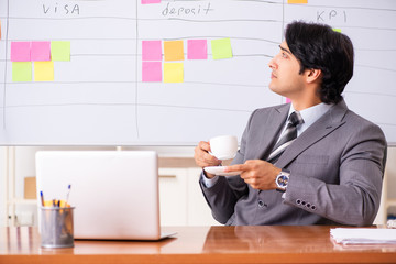 Young handsome employee working in the office