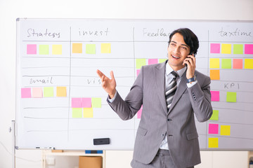 Young handsome employee working in the office