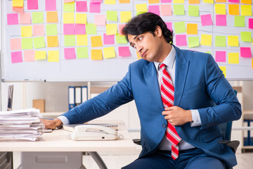 Young handsome employee with many conflicting priorities 