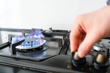 focus on fire. A man lighting the gas-stove with by means of automatic electric ignition. Modern...