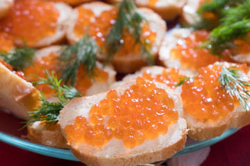 Sandwiches with caviar and butter on a glass platter