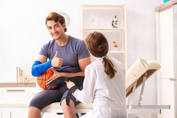 Handsome basketball player visiting female doctor traumatologist