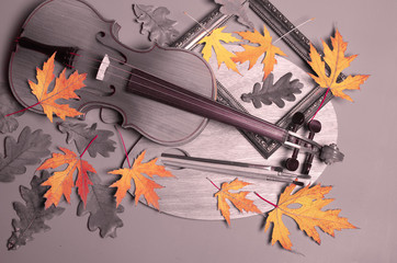 Violin, art palette and yellow autumn leaves