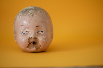 Head of doll against yellow background