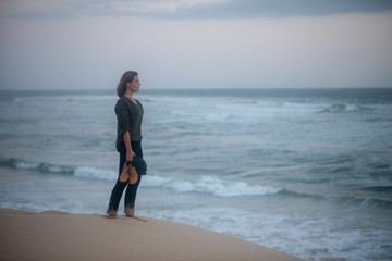 Young woman standing and contemplating at the beach