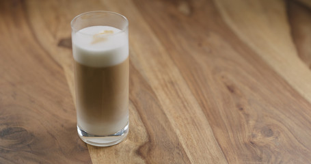 latte macchiato in glass on wood table