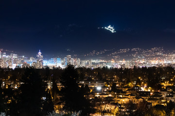 Vancouver city lights with Grouse mountain ski resort on the background, and landmarks: tower, stadium, science museum and houses