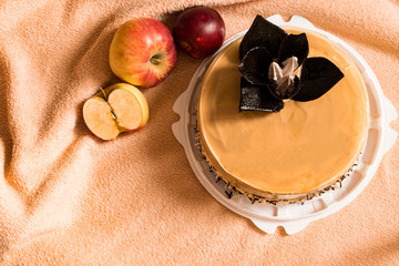 Beautiful cake and apples on orange background
