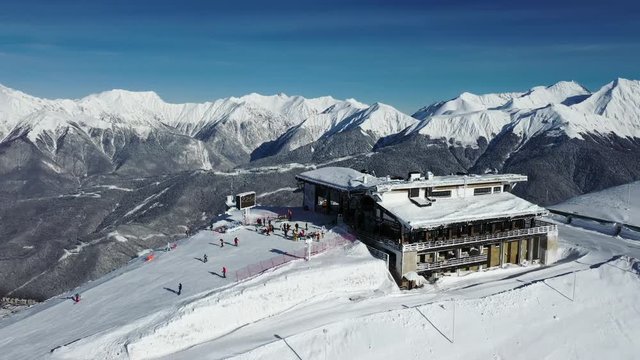Krasnaya Polyana, Sochi. Mountains, snow, skiers, snowboarders, tourists. Vacation in the mountains. Clean air. Aerial photography with quadcopter.